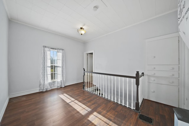 empty room with dark hardwood / wood-style floors and ornamental molding