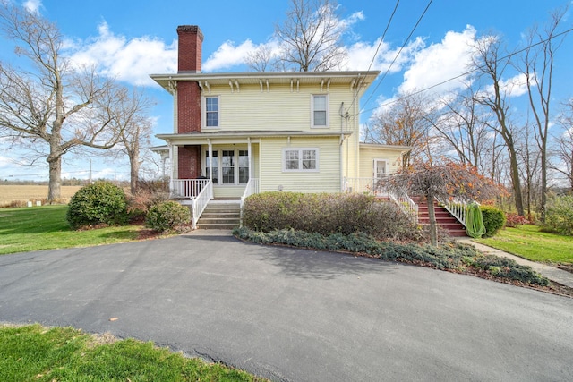 back of property featuring covered porch