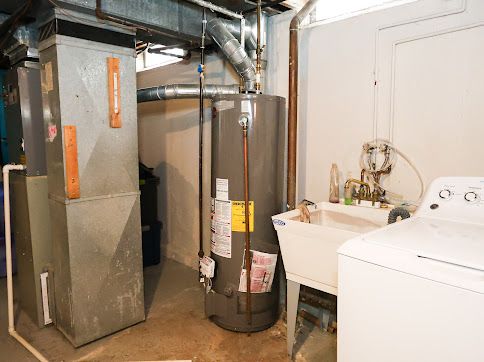 utility room featuring heating unit, washer / dryer, and gas water heater