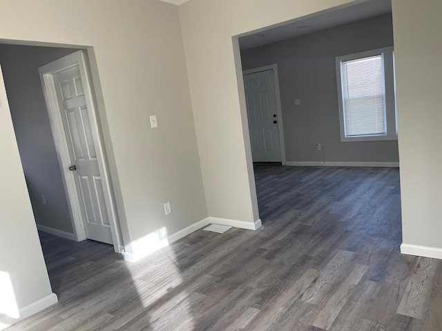 unfurnished room with dark hardwood / wood-style flooring