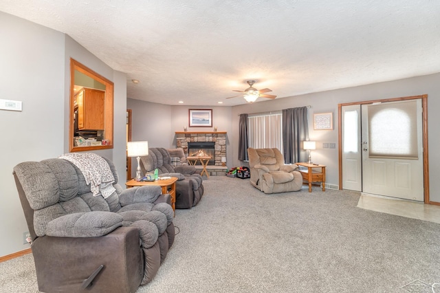 carpeted living room with a fireplace, a textured ceiling, and ceiling fan