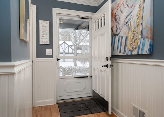 doorway to outside with light wood-type flooring and ornamental molding