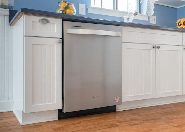 interior details with white cabinets, light wood-type flooring, and dishwasher