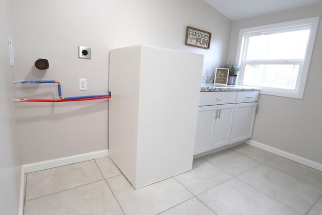 washroom featuring electric dryer hookup and light tile patterned flooring