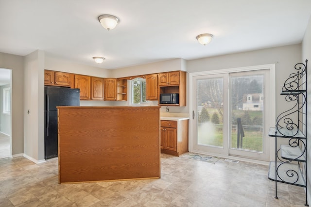 kitchen with a kitchen island and black appliances