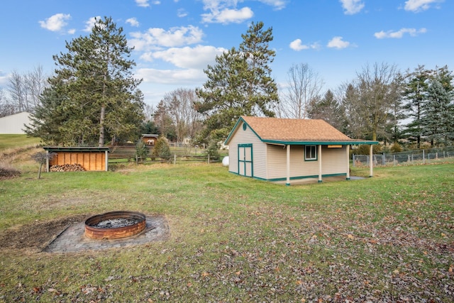 view of yard featuring an outdoor structure and an outdoor fire pit