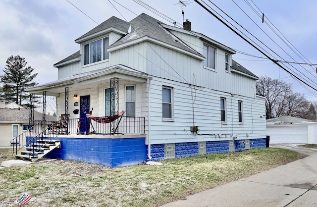 view of front of house with an outbuilding, a porch, and a garage