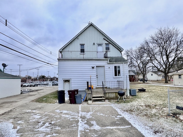 back of property featuring a balcony and central AC