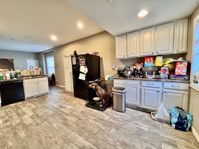 kitchen with black appliances, white cabinetry, and sink