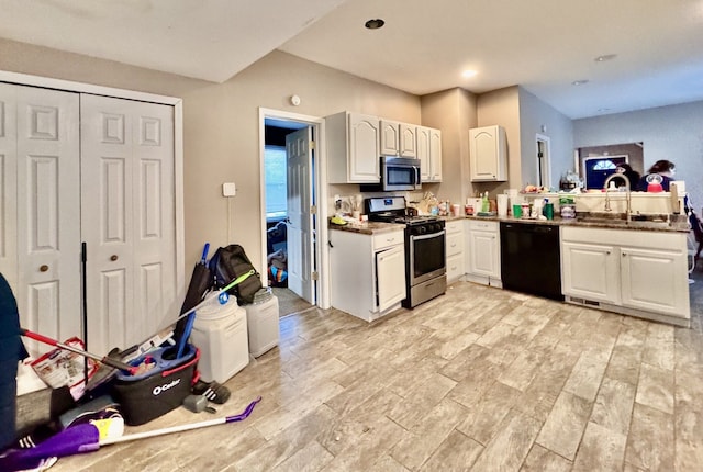 kitchen with kitchen peninsula, white cabinetry, sink, and appliances with stainless steel finishes