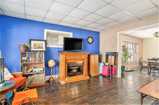 living room with a paneled ceiling and dark hardwood / wood-style floors