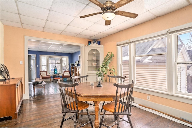 dining room featuring dark wood-type flooring, a paneled ceiling, and ceiling fan