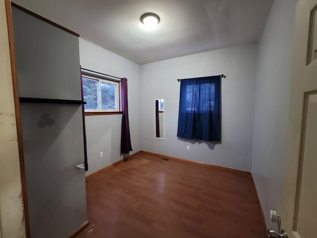 unfurnished room with wood-type flooring