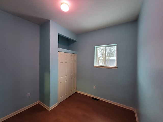 unfurnished bedroom with a closet and wood-type flooring