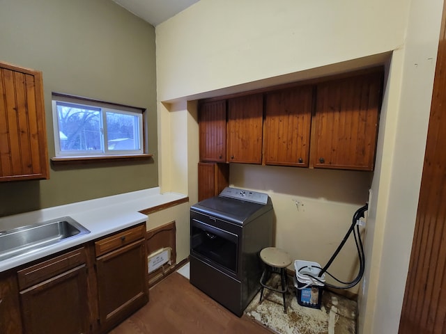 kitchen with sink, wood-type flooring, and washer / dryer