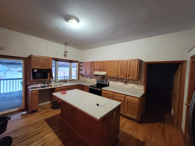 kitchen featuring stainless steel electric range oven, a center island, dark wood-type flooring, tasteful backsplash, and pendant lighting