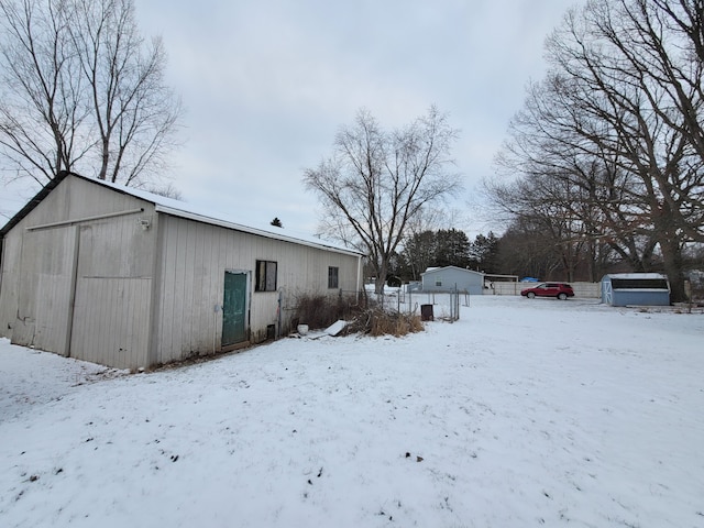 yard layered in snow with an outbuilding