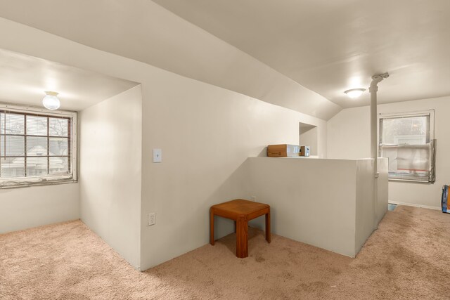 hallway featuring light colored carpet and lofted ceiling