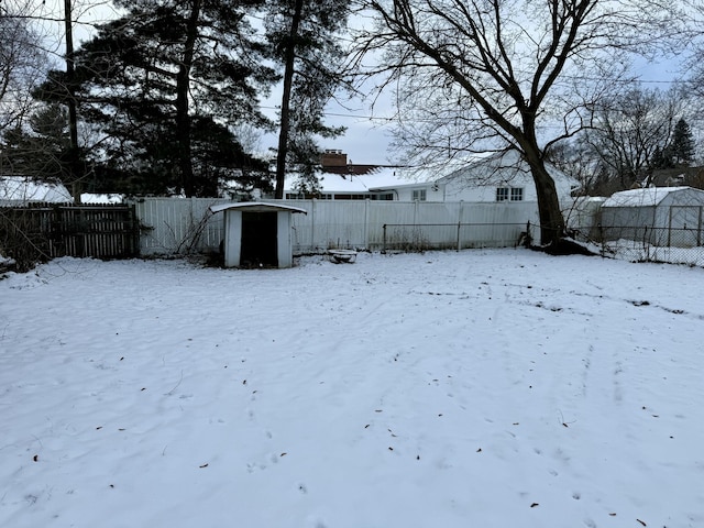 yard covered in snow with a storage shed