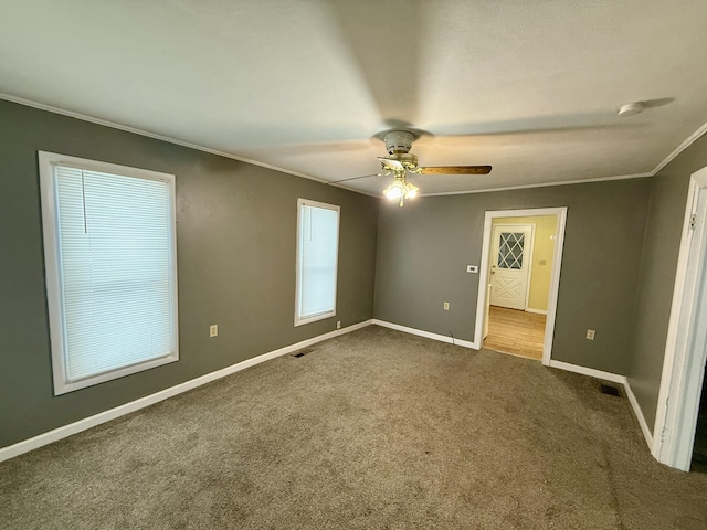 unfurnished bedroom featuring multiple windows, ceiling fan, crown molding, and carpet floors