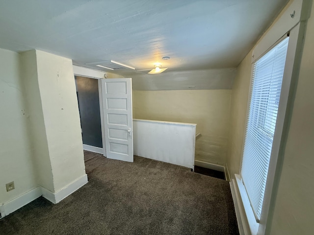 carpeted spare room featuring lofted ceiling