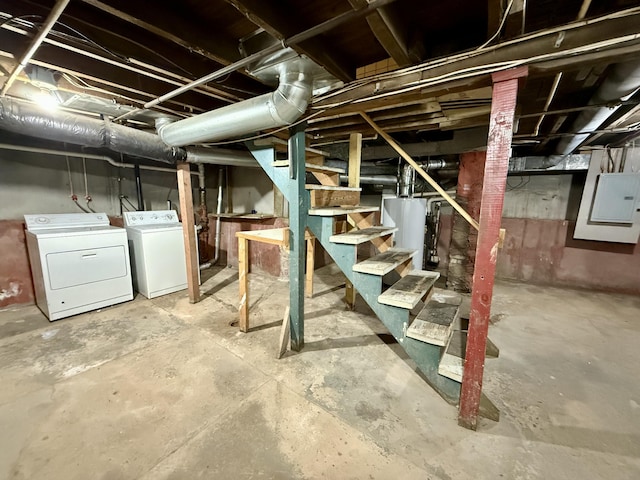 basement featuring washing machine and dryer, electric panel, and gas water heater