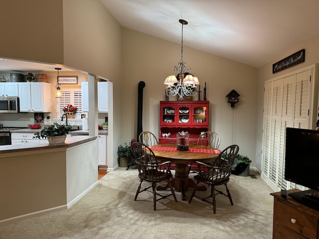 carpeted dining space featuring an inviting chandelier, lofted ceiling, and sink