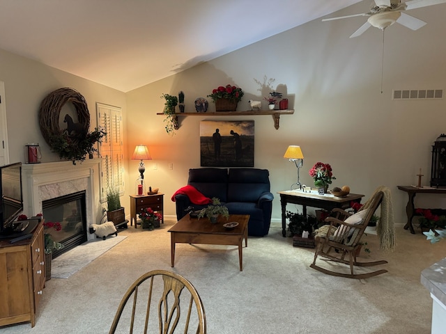 carpeted living room with vaulted ceiling, ceiling fan, and a high end fireplace