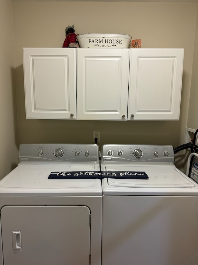 washroom featuring cabinets and washing machine and dryer