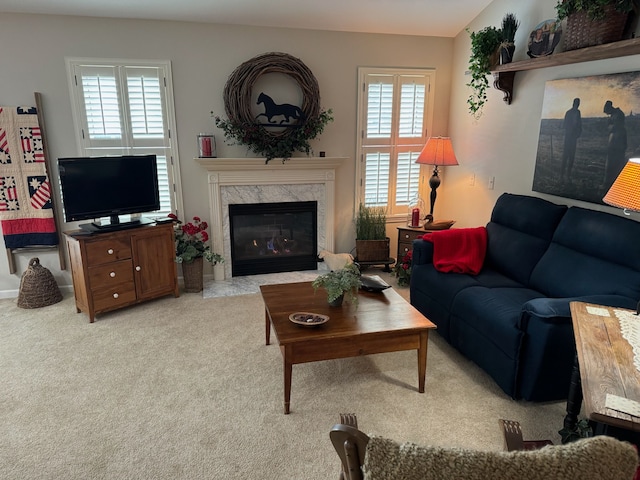 living room featuring light colored carpet, a high end fireplace, and a healthy amount of sunlight