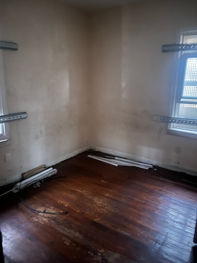 unfurnished room with dark wood-type flooring