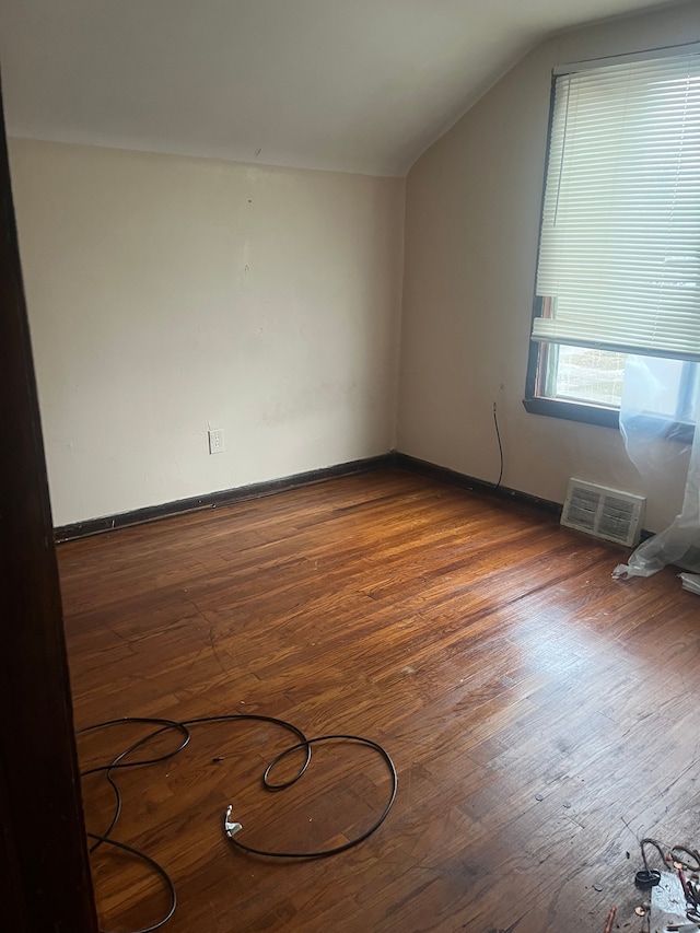 bonus room with dark wood-type flooring and vaulted ceiling