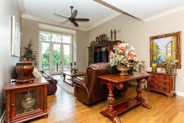 sitting room featuring ceiling fan, light wood-type flooring, and crown molding