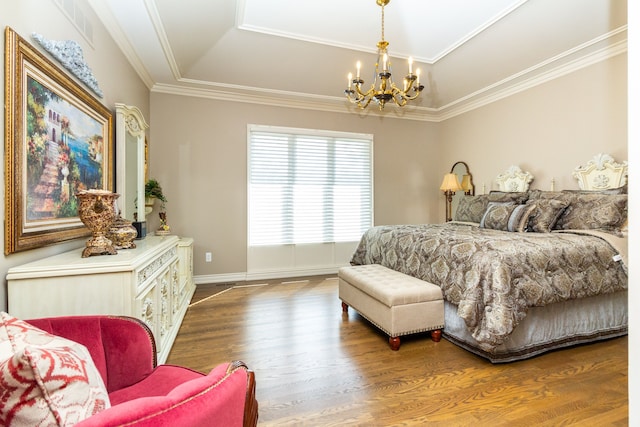 bedroom with a tray ceiling, ornamental molding, hardwood / wood-style flooring, and a notable chandelier