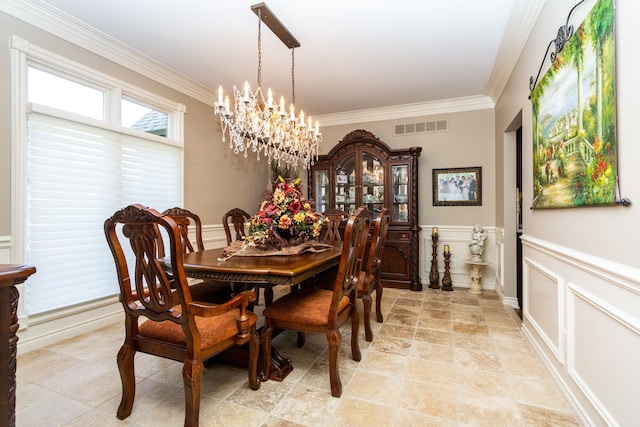 dining space featuring ornamental molding and an inviting chandelier