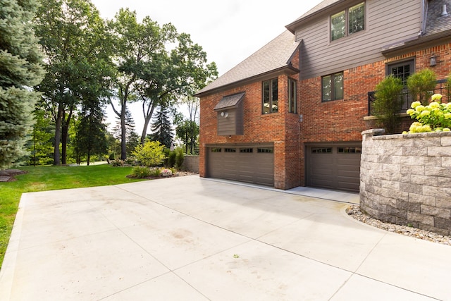 view of property exterior with a garage and a lawn