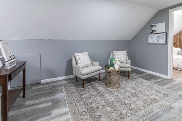 living area with vaulted ceiling and hardwood / wood-style floors