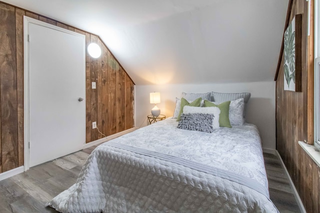 bedroom featuring hardwood / wood-style flooring, lofted ceiling, and wooden walls