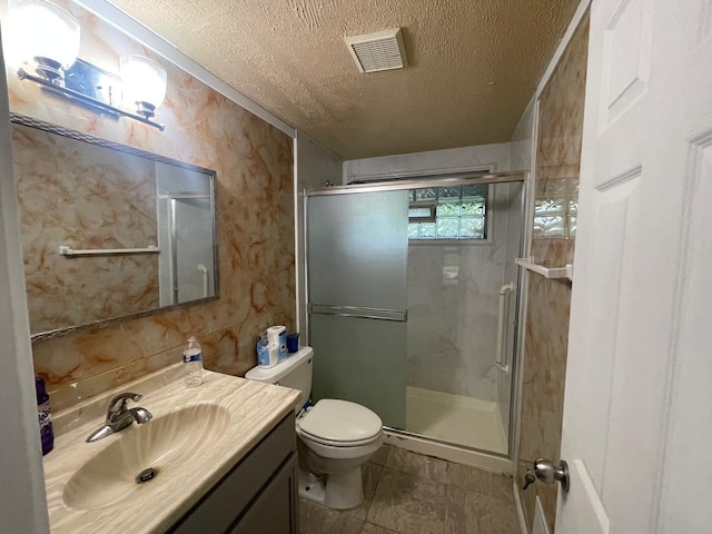 bathroom with an enclosed shower, vanity, toilet, and a textured ceiling