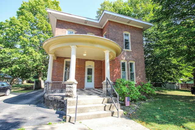 view of front of property featuring covered porch and a front lawn