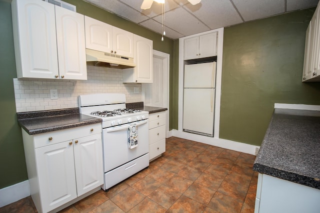 kitchen featuring a paneled ceiling, white cabinetry, white appliances, and tasteful backsplash