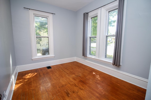 unfurnished room with hardwood / wood-style flooring