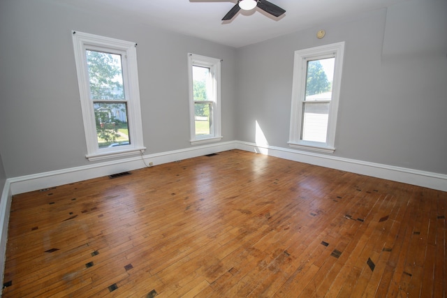 empty room featuring hardwood / wood-style flooring, ceiling fan, and a wealth of natural light