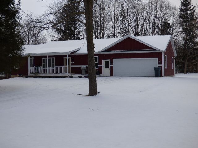 ranch-style house featuring covered porch and a garage