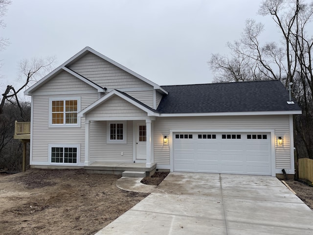 view of front facade with an attached garage, a balcony, driveway, and a shingled roof