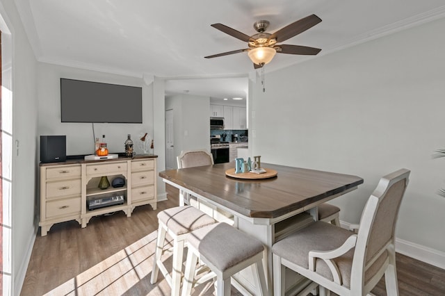 dining space featuring dark hardwood / wood-style floors, ceiling fan, and crown molding