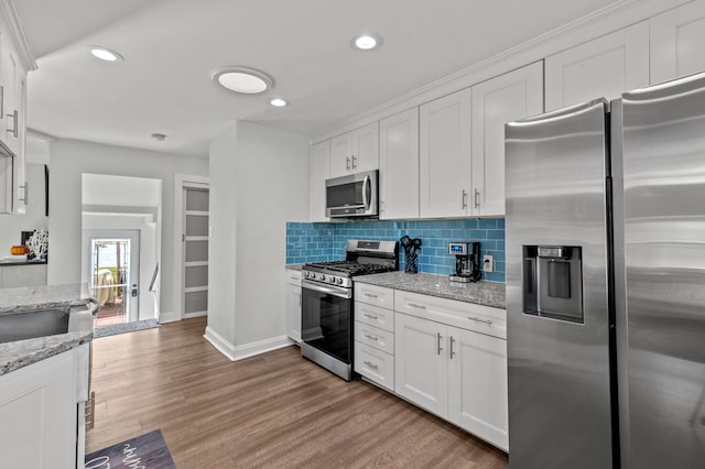 kitchen with white cabinets, light stone countertops, and stainless steel appliances