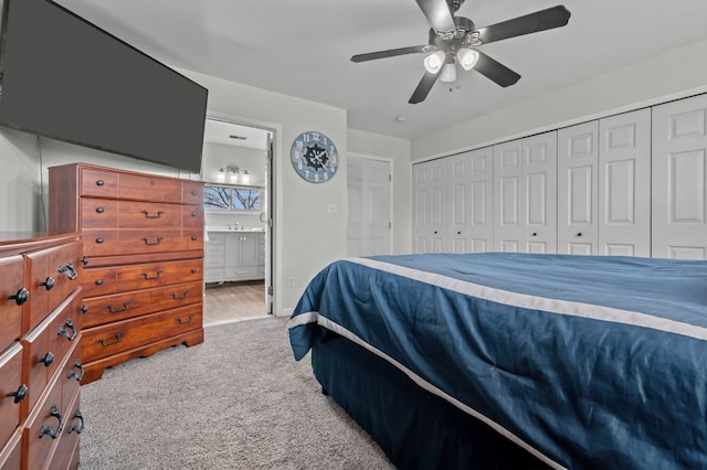 bedroom featuring light colored carpet, ensuite bath, and ceiling fan