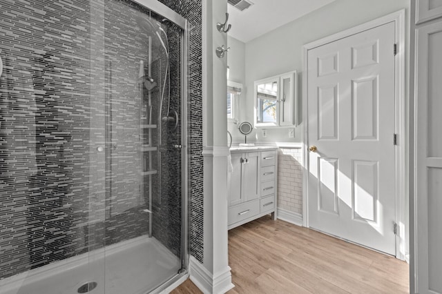 bathroom featuring a shower with door, vanity, and hardwood / wood-style flooring