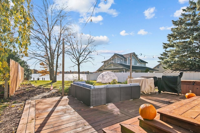 wooden terrace with outdoor lounge area, a water view, and a grill